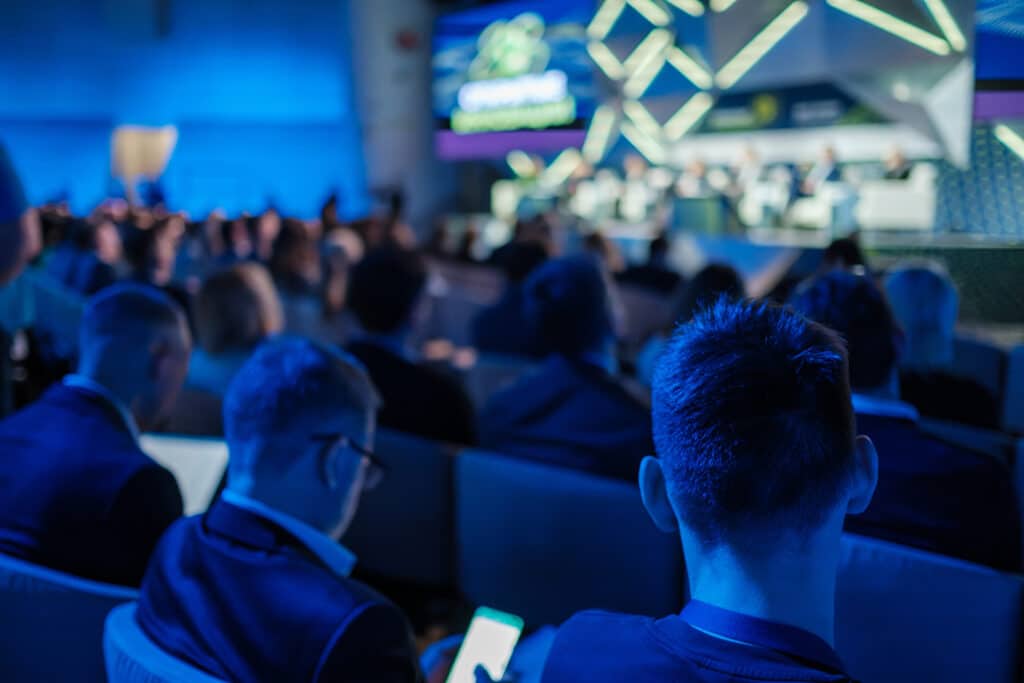 Smartly dressed audience is engrossed in a business conference presentation