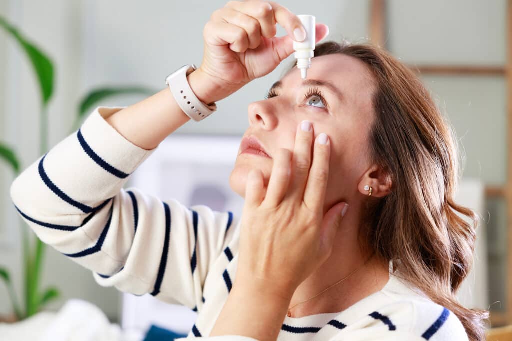 Woman using eye drops for Uveitis